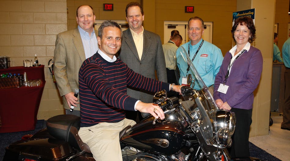 M.Todd Cramer, president of Johnstone Supply &ndash; Knoxville sits astride the Harley won by the company team. Awaiting their turns are (l to r), Rod Rushing, vice president and general manager Unitary Products at Johnson Controls; DeWight Wallace, CEO of Johnstone Supply; Tim Brusseau, UPG strategic distribution account manager at Johnson Controls; and Lori Hayes, product manager &ndash; HVAC equipment at Johnstone Supply.