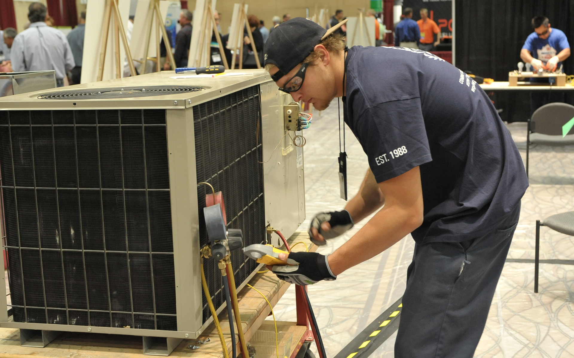 Tyler Plueger winner of the 2013 PHCC Educational Foundation HVAC contest takes readings on a package unit during the skills assessment portion of last yearrsquos competition