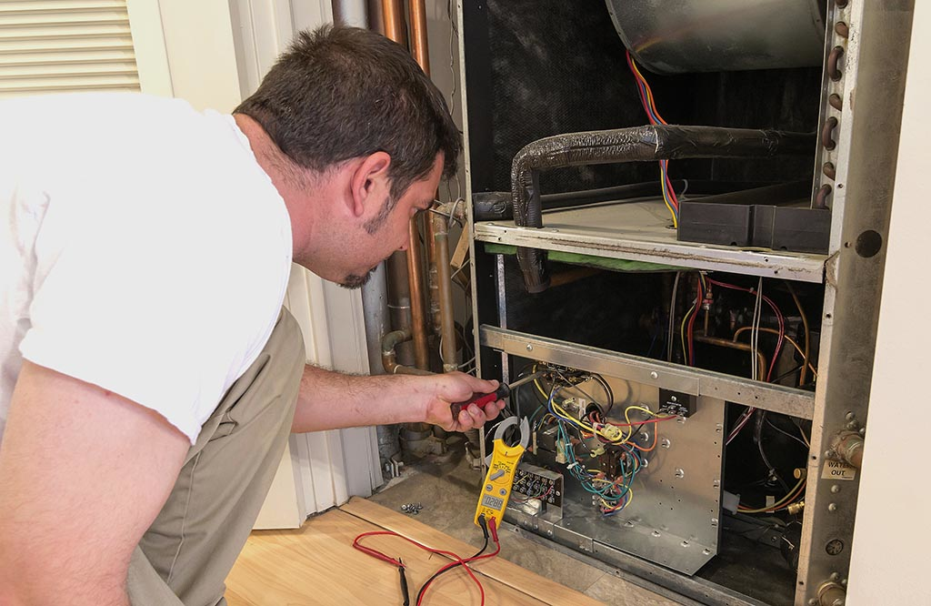 Air conditioning service technican checking voltage on a blower motor