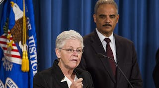 EPA Administrator Gina McCarthy speaks as U.S. Attorney General Eric Holder looks on during a press conference to announce a settlement between the U.S. government and Hyundai Motor Company and Kia Motors Corporation, at the Justice Department headquarters, November 3, 2014 in Washington, DC.