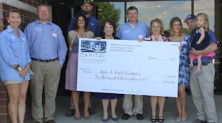 Photo shows presentation at the grand opening event. Capital Heating &amp; Cooling presented a $5,000 check to Make-A-Wish. The HVAC system in the building was donated by the Luxaire brand of Johnson Controls and installed by Capital Heating &amp; Cooling.