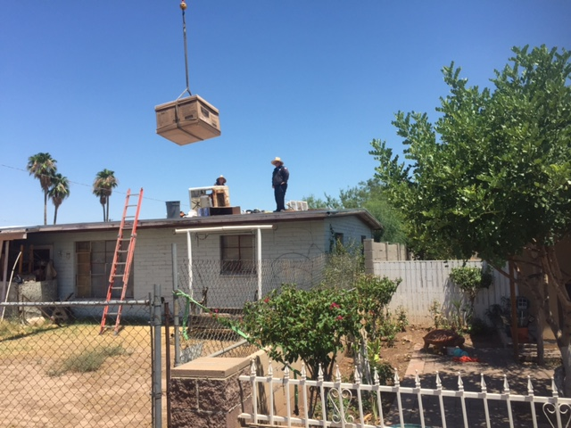 Ben Ousleyrsquos new evaporative cooler a gift of Goettl AC Pheonix AZ is lifted into place