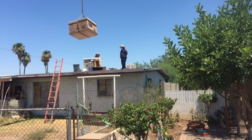 Ben Ousley&rsquo;s new evaporative cooler - a gift of Goettl AC, Pheonix, AZ, is lifted into place.