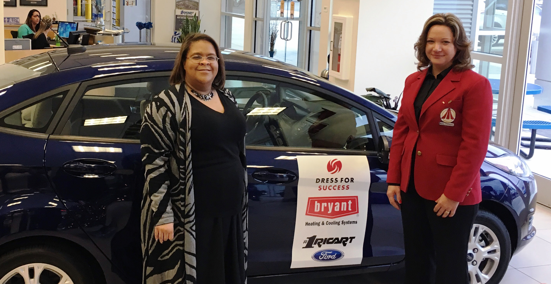 Leeza Crosby Edwards left and Natalie Tevis President of Airclaws Inc and Bryant Heating amp Cooling Systems Medal of Excellence recipient stand in front of the new Ford Fiesta donated to Leeza for her participation in the 39Dress for Success39 program