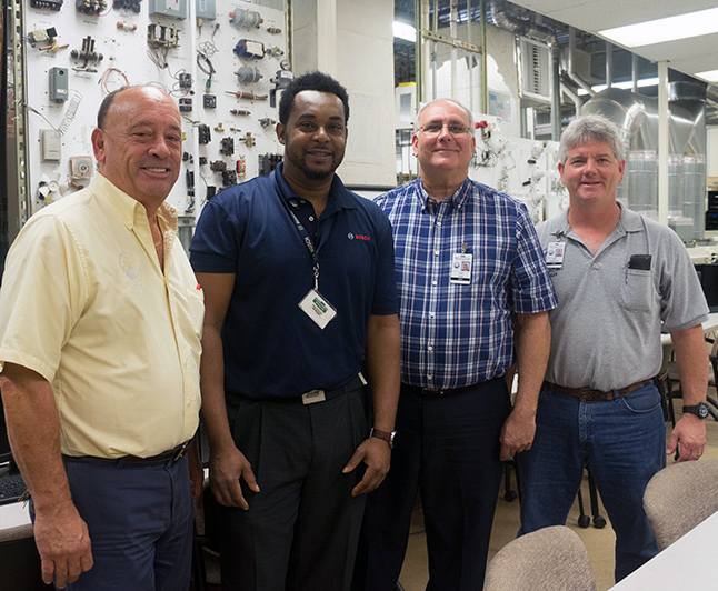From left are James Blackford III HVACR educator Omar Mcintosh technical service associate John Felser assistant principal and Brian Youngblood HVACR educator
