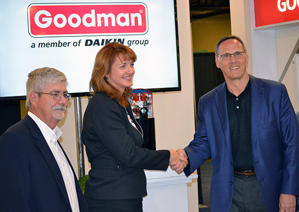 Brandy Powell vice president and general manager residential air conditioning for Emerson39s Commercial and Residential Solutions platform and Larry Blackburn executive vice president and president Goodman Business Unit shake hands during the announcement that Goodman and Emerson will combine technologies for a new 1618 SEER comfort system Karl Zellmer vice president air conditioning sales for Emerson is at left