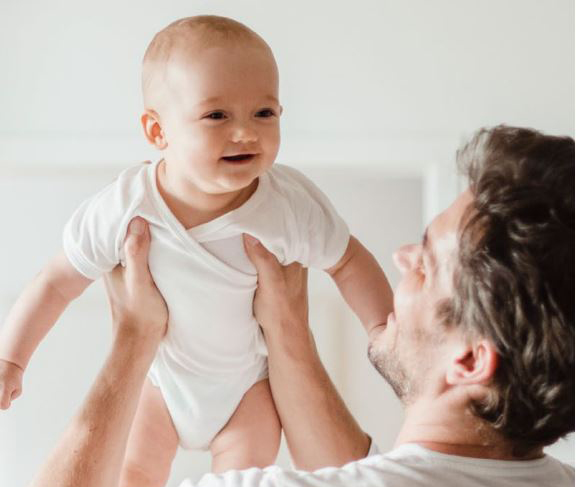 dad lifting baby