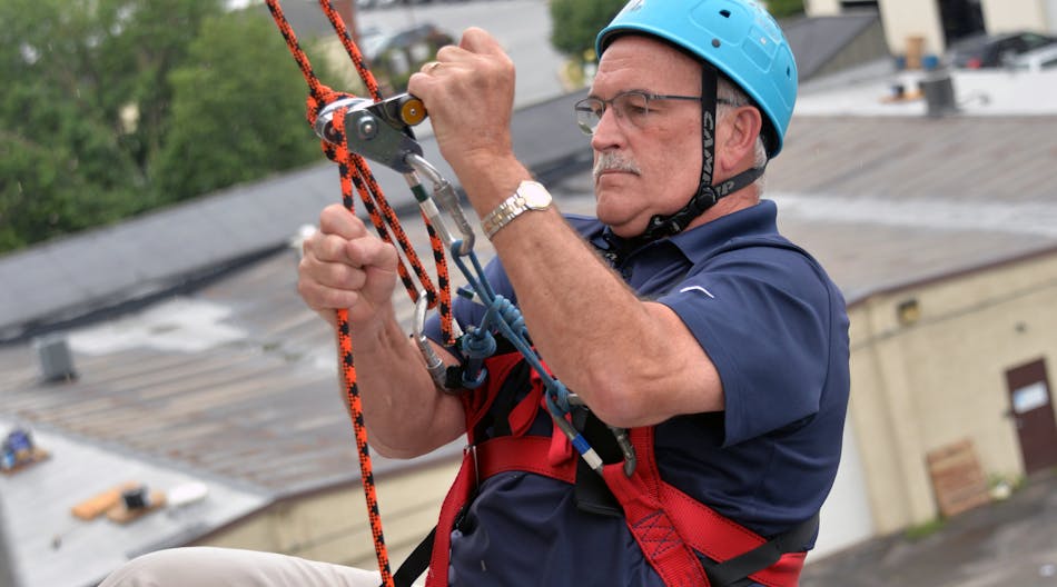 Yeah, right! Bill Ronanye the rappeller descends one floor at a time for a community cause.