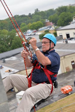 Yeah, right! Bill Ronanye the rappeller descends one floor at a time for a community cause.