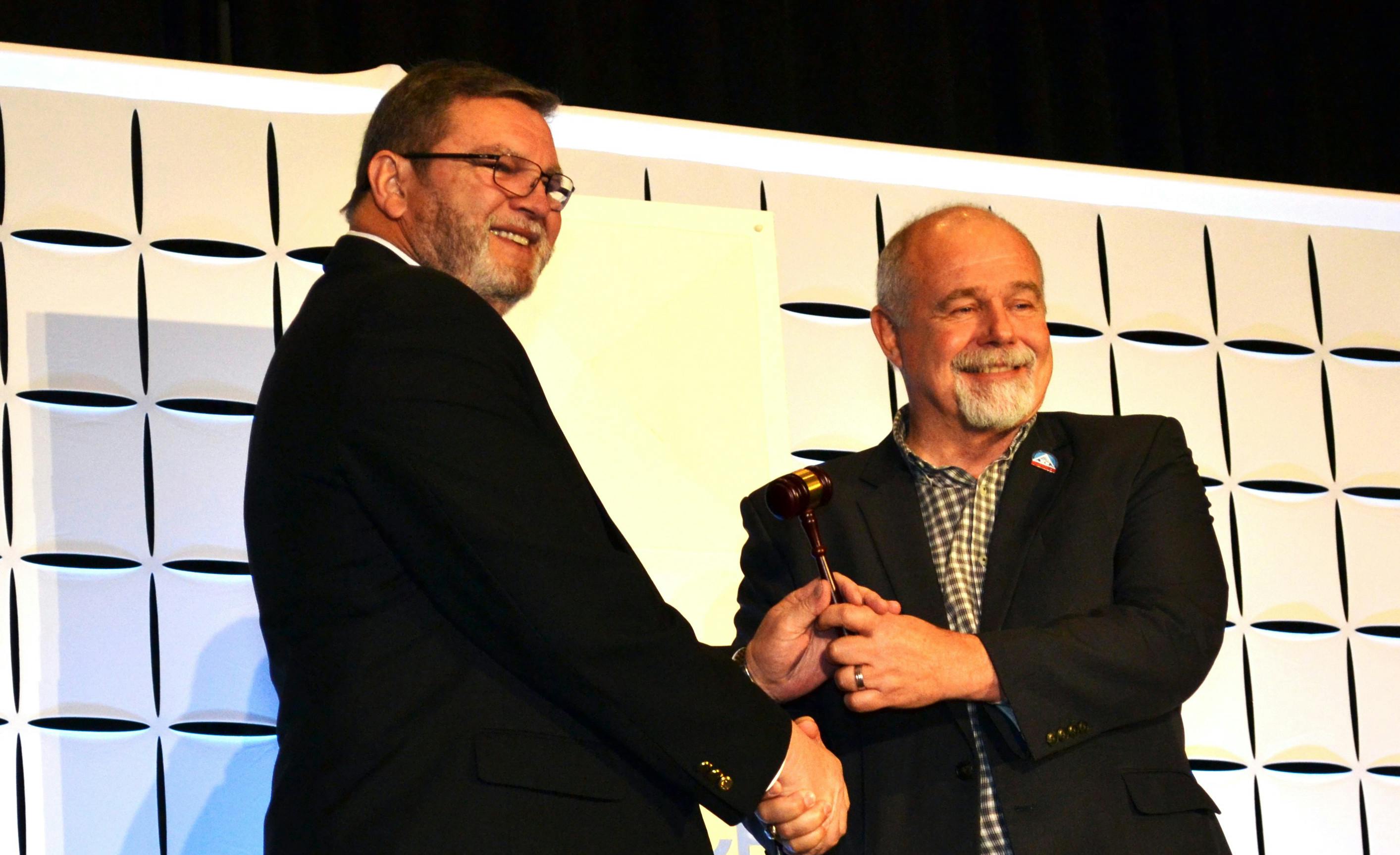 Steve Pape, right, passes the ACCA Chairman's gavel to 2024-25 ACCA Chairman Martin Hoover.