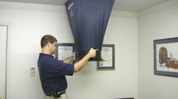 Photo 1: Delivered airflow into the living space is the core test in measuring system performance. A much younger David Richardson measures airflow from a supply register for demonstration purposes.