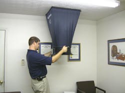Photo 1: Delivered airflow into the living space is the core test in measuring system performance. A much younger David Richardson measures airflow from a supply register for demonstration purposes.