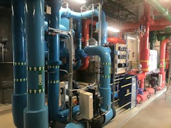 Figure 3: While central plants are often concealed, the Vancouver Island Schools prioritize plant visibility for educational purposes. The plant was designed to be a learning hub, including features such as color-coded pipes and a TV dashboard that displays plant data. As a result, industry professionals and the public can learn more about the inner workings of district heating applications. Figure 3: While central plants are often concealed, the Vancouver Island Schools prioritize plant visibility for educational purposes. The plant was designed to be a learning hub, including features such as color-coded pipes and a TV dashboard that displays plant data. As a result, industry professionals and the public can learn more about the inner workings of district heating applications.