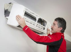 Dale Comeau removes the cover on a wall-mounted mini-split unit. Dale Comeau removes the cover on a wall-mounted mini-split unit.
