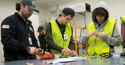 Camp attendees working with electrical components. Camp attendees working with electrical components.