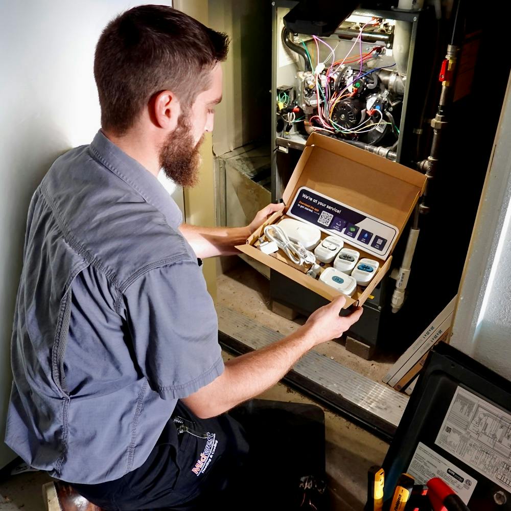 A Midwest Heating &amp; Cooling technician installing the SmartAC sensor kit.