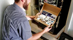 A Midwest Heating & Cooling technician installing the SmartAC sensor kit.