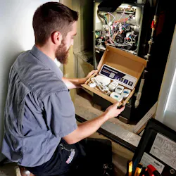 A Midwest Heating & Cooling technician installing the SmartAC sensor kit.
