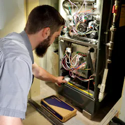A Midwest Heating & Cooling technician installing the SmartAC sensor kit.